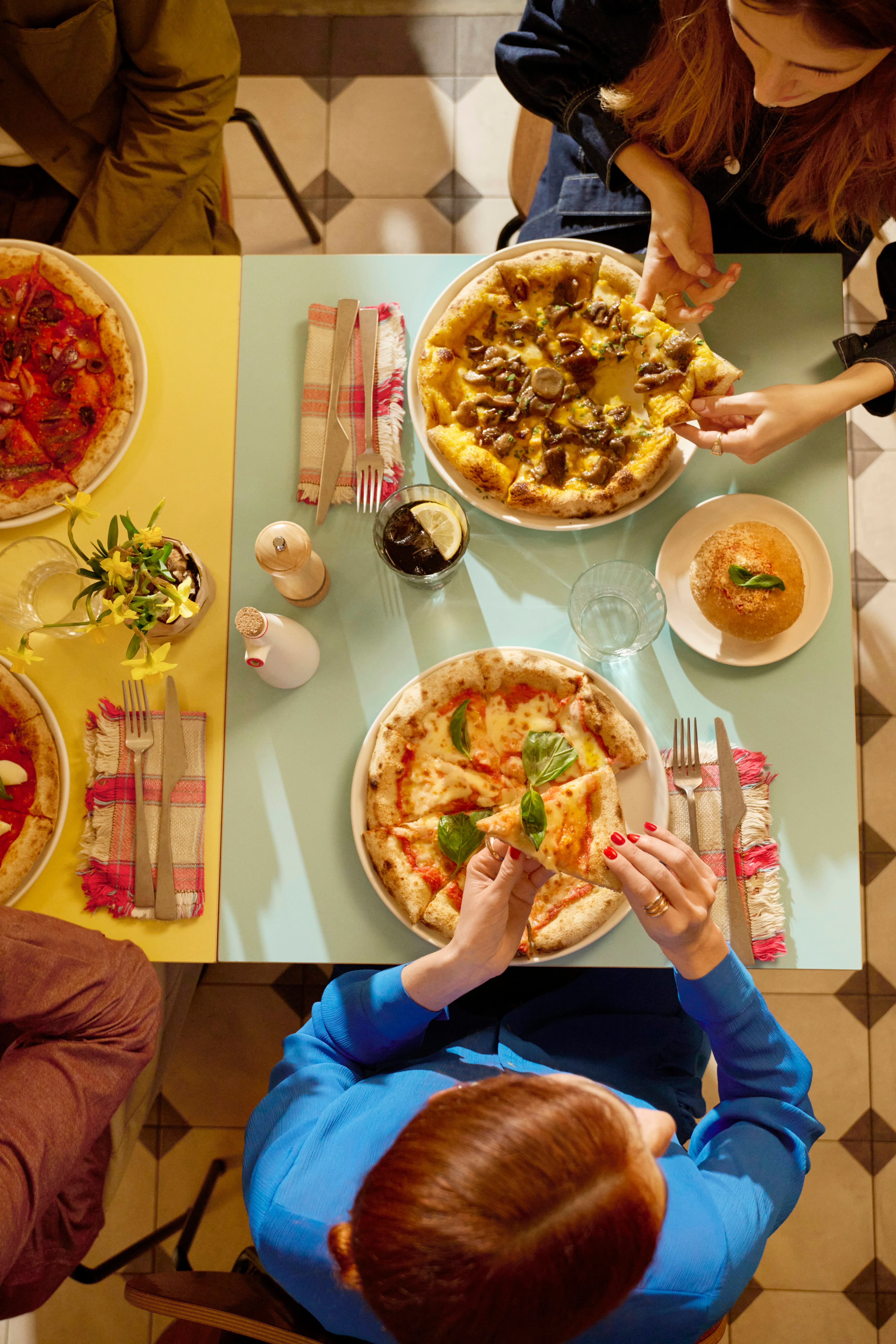 Amici che mangiano una pizza assieme e pagano con Satispay